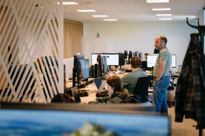 Several ACEN professionals sitting at their desk at the Kontich office.