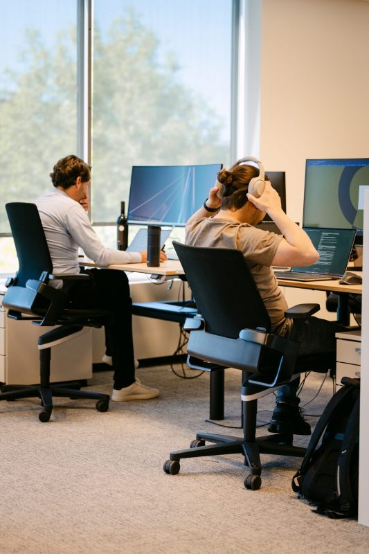 Two ACEN professionals sitting at their desk at the Kontich office.