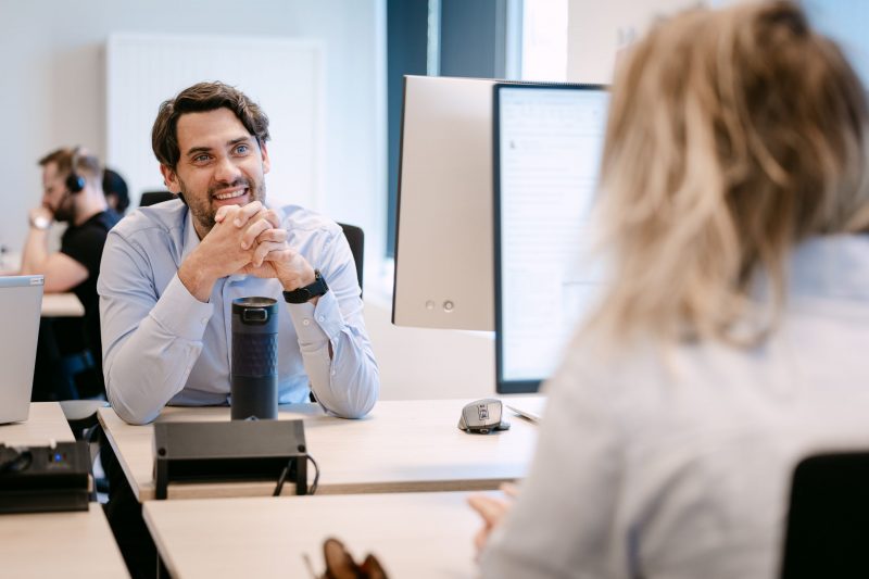 One of the Managing Partners sitting and talking behind his desk.