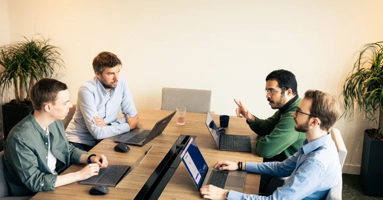 Photo of the PAM team in the office, during a meeting.