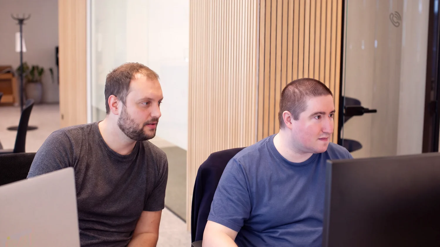 Identity & Governance Administration team at work in the office, looking at a pc screen.
